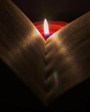 Reading a book by candlelight Stock Photos