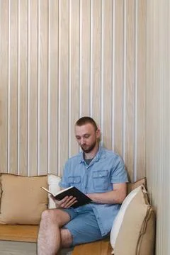 Reading a book in a cozy nook while working remotely from a modern space de.. Фото