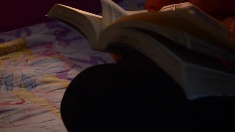 Reading a book on a dim light. 動画素材 104763957