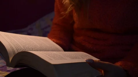 Reading a book on a dim light. 動画素材 104764046