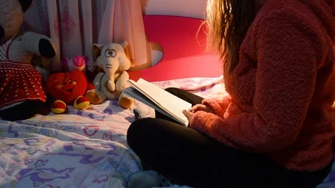 Reading a book on a dim light. 動画素材 104764072