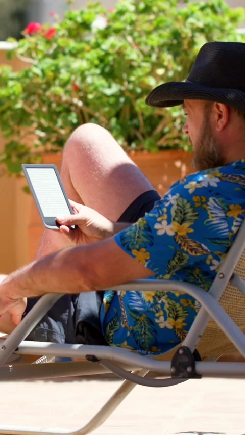 Reading a book on an e-reader while rela... | Stock Video | Pond5