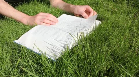 Reading book in grass Vídeo Stock 11868091