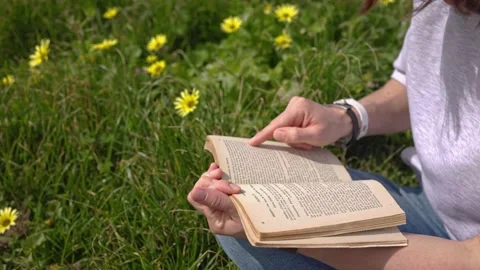 Reading a book on green grass. Stock Footage 194957155