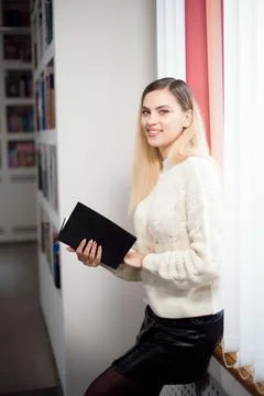 Reading book in library. Student in the library with a book in her hands. Foto stock