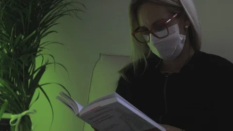 Reading a book with the mask, because the covid-19 is a risk Stock Footage 126228341