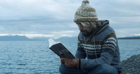 Reading a book at mountain lake Stock Footage 90076147