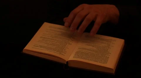 Reading the book slow motion with isolated hand black background Stock Footage 57885992