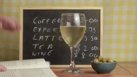 Reading book while enjoying white wine in cafe close up Stock Footage 135174738