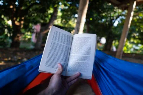 Reading book while laying in hammock Stock Photos