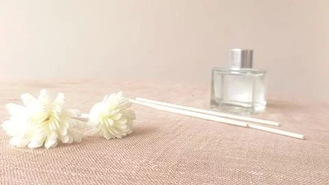 Reading the box of the white flower with a bottle of perfume on a table Stock Footage 146254326