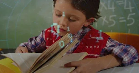 Reading boy wearing red patterned vest over plaid at school desk with book and 写真素材