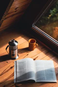 Reading corner concept: Cozy composition of coffee and a book in bungalow hou Fotos Stock