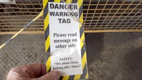 Reading a danger tag being to control entry to work areas Stock Footage 108496278