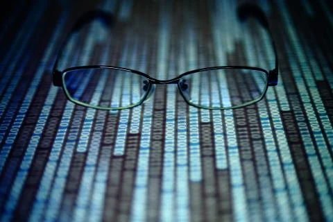Reading data in digital age. glasses and flowing binary code matrix. shallow Stock Photos
