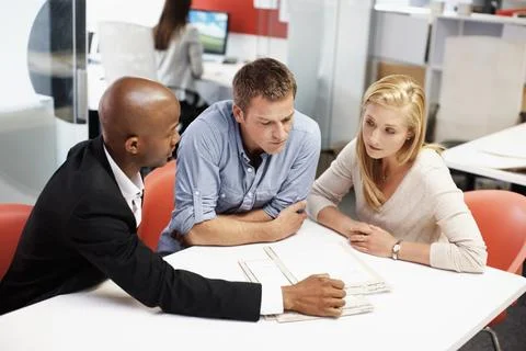 Reading, documents and financial advisor with couple in office, meeting and plan Stock Photos