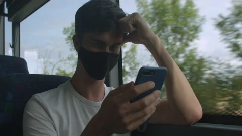 Reading an e-book in a mask on the bus. Focus of attention on the phone screen. Видео 160129341