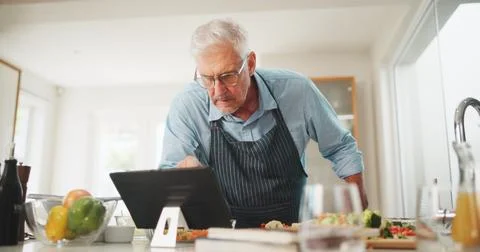 Reading, elderly or man with tablet for cooking recipe tutorial, lunch and guide Foto stock