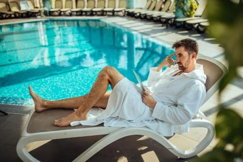 Reading emails by the pool Stock Photos