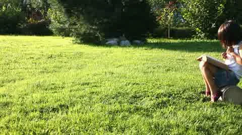 Reading girl on grass Stock Footage