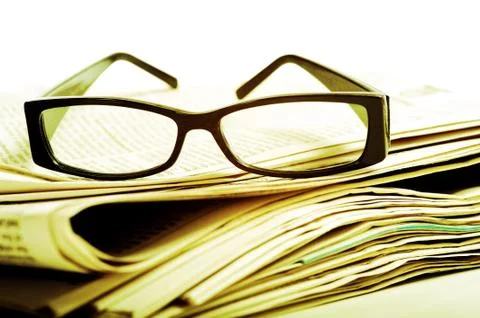 Reading glasses on newspapers Stock Photos