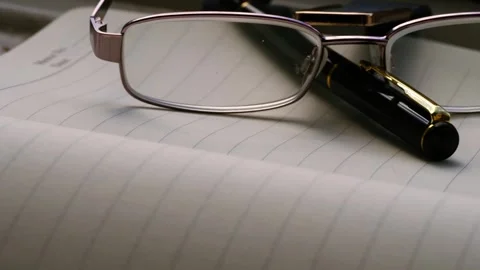 Reading glasses on notepad diary journal Stock Footage 278529342