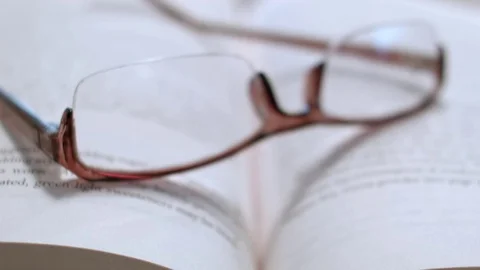 Reading Glasses On Top of an Open Book, Zoom In Vidéo 76766841