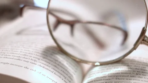 Reading Glasses On Top of an Open Book, Zoom In  Vídeo Stock 76767228