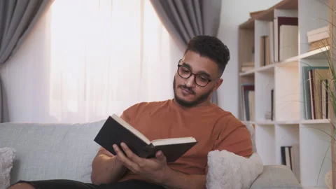 Reading hobby book lover smart guy on home couch Stock Footage 201665668