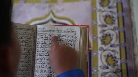 Reading the Koran on a prayer mat Stock Footage 295435560