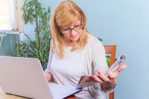 Reading a magazine and browsing computer Stock Photos