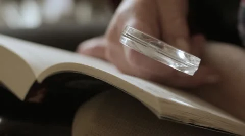 Reading with magnifying glass Stock Footage 12661454