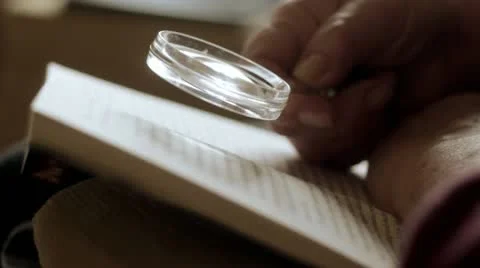 Reading with magnifying glass Video stock 12661559