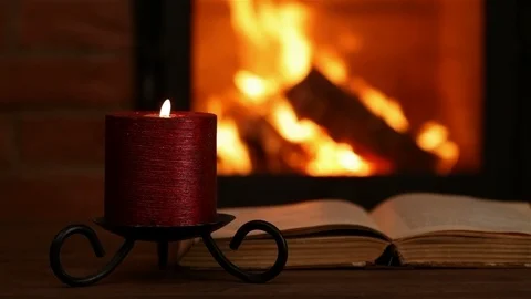 Reading an old book at the fireplace Stock Footage 94252782