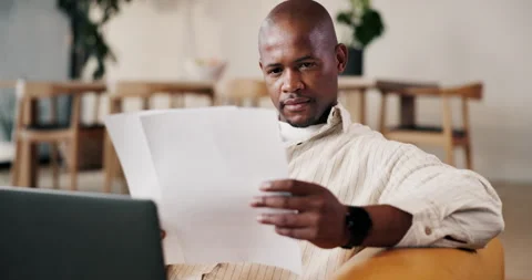 Reading, paperwork or black man with remote work on sofa, narrative summary or Stock Footage 336851773
