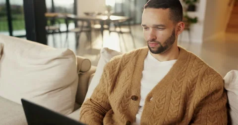 Reading, remote work and man with laptop on sofa, maintenance planning and Stock Footage 335268157