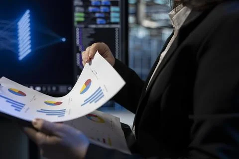 Reading report files, cloud computing rigs and worker in server room, close up 库存照片