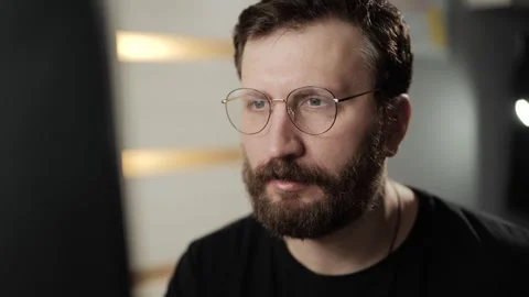Reading, research, work concept. Concentrated man in glasses reading something o Видео 303948251