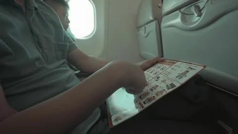 Reading Safety Instructions on an Airplane Stock Footage 314665003