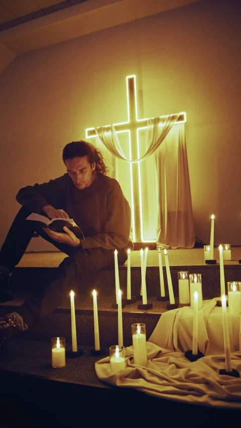 Reading Scriptures by the Light of Neon Cross and Digital Flames Stock-Footage 327207469