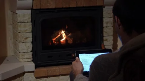Reading On A Tablet In Front Of A Fireplace Old and Modern Concept Stock Footage 44015272