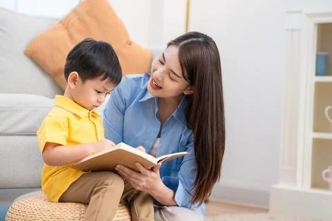 Reading time between a mother and her child in a living room during the aft.. Stock Photos
