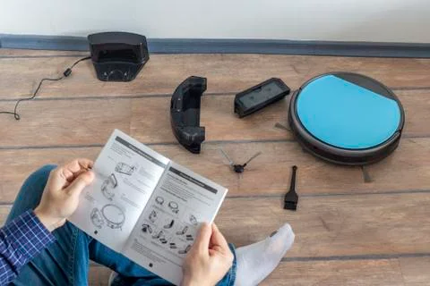 Reading the user guide for robot vacuum cleaner Stock Photos