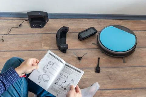 Reading the user guide for robot vacuum cleaner Stock Photos