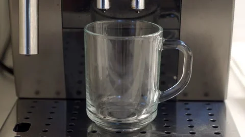 Ready to Brew: Clear Mug Awaits as Coffee Machine Hums to Life. Stock Footage 320848740