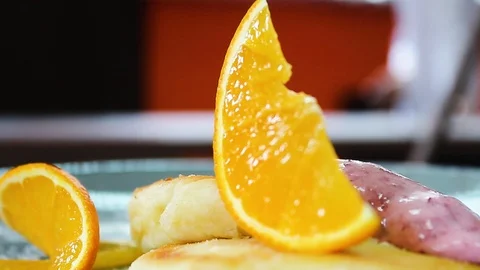 Ready cheesecakes with two sauces and a slice of orange on a plate Stock Footage 112508853