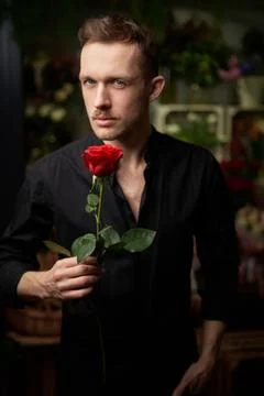 Ready for date macho man with red rose, vertical photo Stock-Fotos