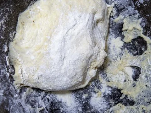 Ready dough for baking in a pan. Raw thick dough. Before making pies. Knead.. Stock Photos