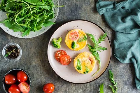 Ready to eat egg, broccoli and tomato frittata on a plate on the table. Hom.. Stock Photos