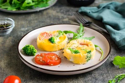 Ready to eat egg, broccoli and tomato frittata on a plate on the table. Hom.. Stock Photos